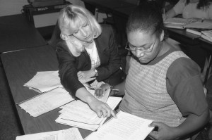 Michele Geers (left), Accounting faculty member, helps unidentified female student with classwork (ca. 1980s)